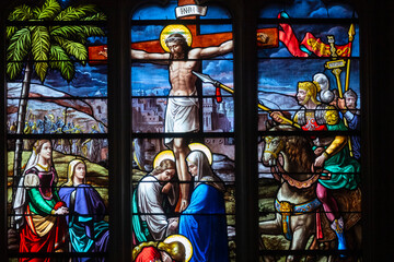 Stained glass (19th century) of Jesus Christ crucified on the cross represented with Marie and...