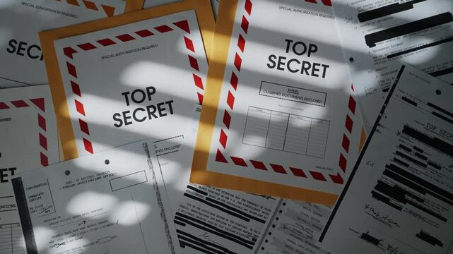 Various classified and top secret documents and envelopes in dark room. Mysterious and secretive mood in office desk with window shadow on files and papers. Confidential information with censored text