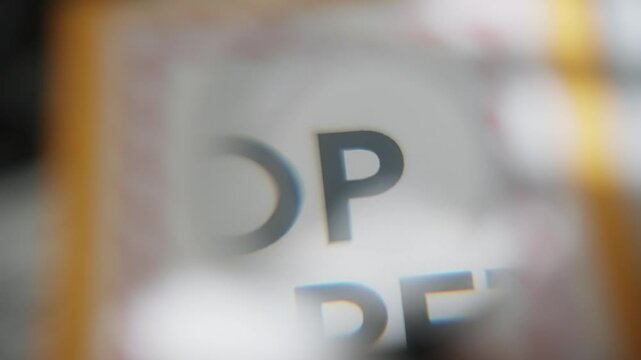 Magnifying glass showing Top Secret label on official old and retro envelope. Sensitive government intelligence material. Conspiracy or spy leaking information. Close up on text on manila folder