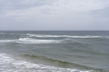 Moody sea waves rolling under an overcast sky