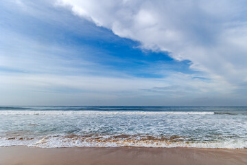 Beautiful landscape with blue sky and soft cirrus clouds over calm Indian Ocean with small foamy waves in Sri Lanka, Asia