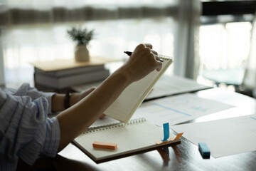 the businessman is sitting at a desk with a calculator and a stack of papers. She is looking at the...