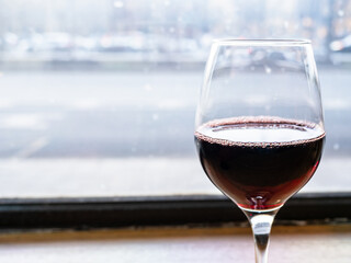 glass of red wine close up on windowsill in bar
