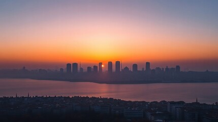Fototapeta premium City skyline silhouette at sunset across a body of water