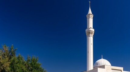 Obraz premium A tall white minaret and dome against a deep blue sky