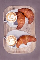 colazione italiana sul vassoio con cappuccino e croissants