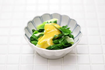 boiled young daylily leaves topped with mustard and vinegared miso. An spring appetizer of Japanese cuisine.