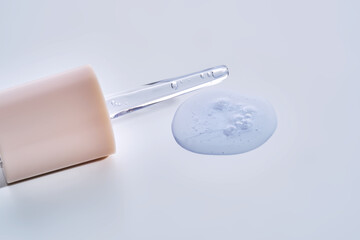 Pipette with delicate blue serum close-up.