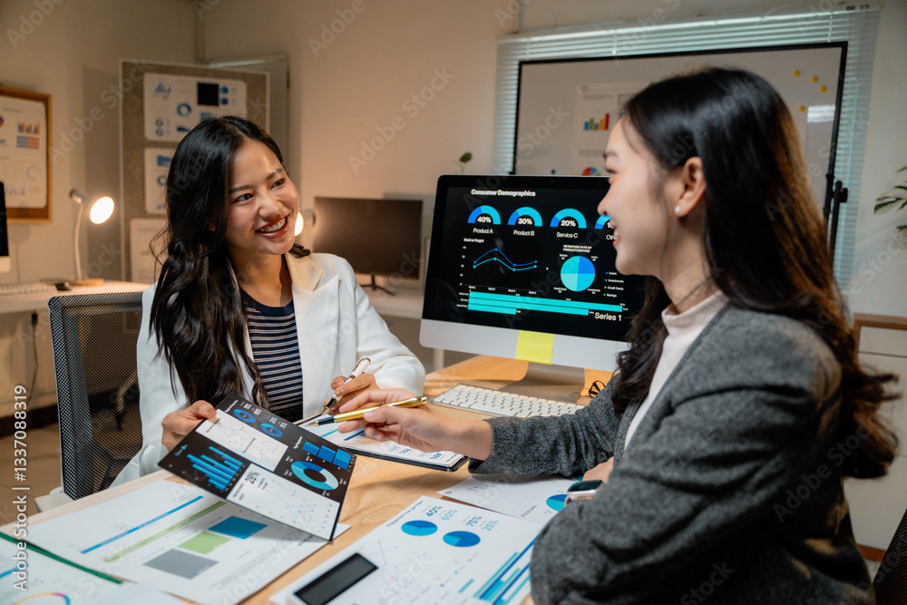 Aufkleber Asian businesswomen discussing marketing strategy analyzing statistical charts displayed on computer screen and printed documents