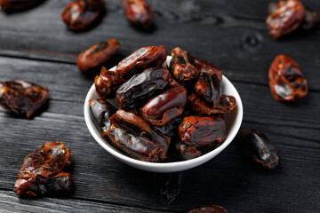Dried sweet pitted dates in white bowl. Healthy food