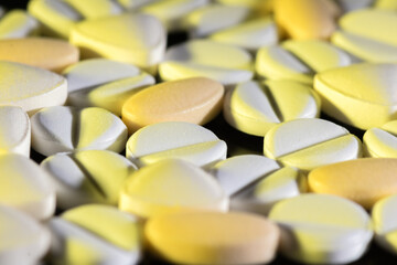 Various Yellow and White Capsules Arranged in a Close-Up View