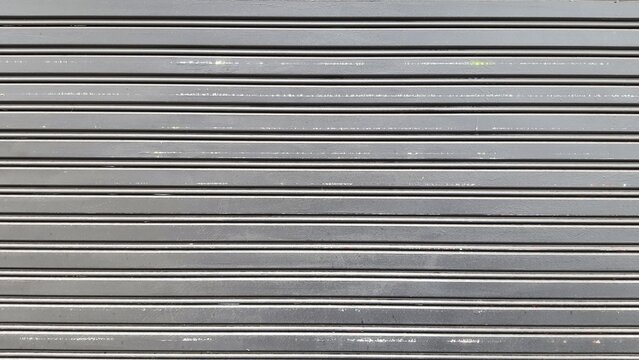 Rolling door. Steel shutter door of warehouse. The shutters are gray metal. Steel rolling shutter background. Silver metal rolling shutter background. Background images and texture images.