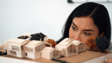 Cropped image of caucasian skilled architect engineer focus on checking architectural model. Checking inspect house model structure and quality. Creative design concept. Closeup. Immaculate.