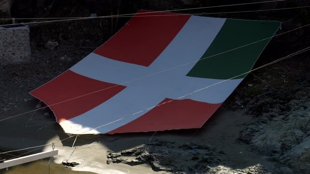 Italy, Ivrea, 03-02-2025. Ivrea big banner Rione del borghetto in city center of Ivrea at the historical carnival. Tilt 4K