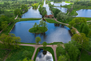 A panoramic view from a height of the ponds and the Landscape Park in Peterhof, the meadow garden, walking paths, the destroyed pavilion.