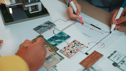 A team collaborates on an interior design project, sketching a floor plan while using color...