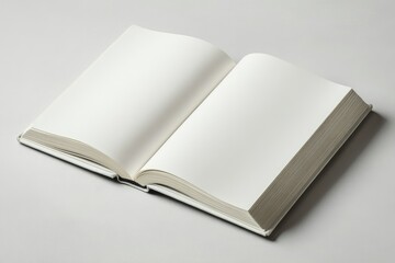 Fototapeta premium A blank, open book lies on a light gray surface, ready for writing or reading.