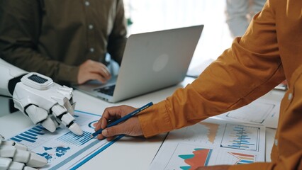 Business professionals engaged in data analysis, utilizing technology and collaboration to enhance productivity and insights in a modern office setting.Noogenesis