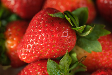 juicy red strawberry with green leaves close-up