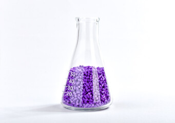 Purple masterbatch granules in Erlenmeyer flask isolated on white background, color pigment carrier...