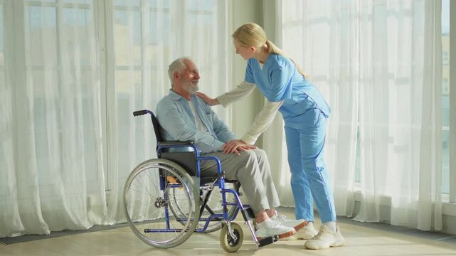Help support retirement healthcare. Nurse helping old man in wheelchair. Patient and woman in nursing home for medical caregiver. Nurse taking care of paralyzed man in chair for people with disability