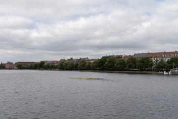 Obraz premium A wide-angle panoramic view of Copenhagen across its river, capturing the city's architectural beauty and vibrant skyline.