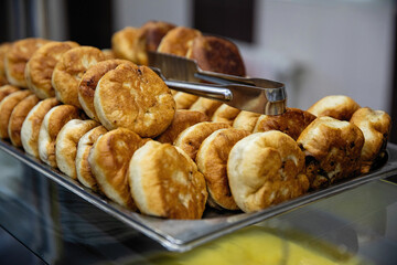 Prepared buns with meat on a tray. Belyashi. Catering.