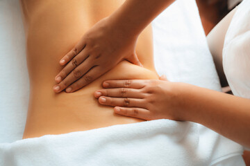 Closeup woman customer enjoying relaxing anti-stress spa massage and pampering with beauty skin recreation leisure in day light ambient salon spa at luxury resort or hotel. Quiescent