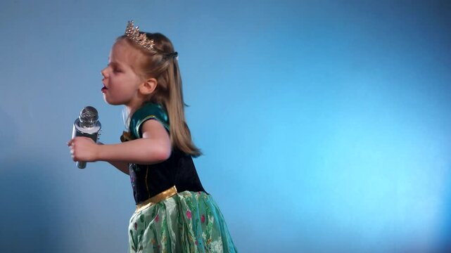 A little princess, voice soaring, a captivating performance. The Queen sings into the microphone and dances. Karaoke. Emerald gown, sparkling crown, a tiny starlet takes the stage. Hands clasped 