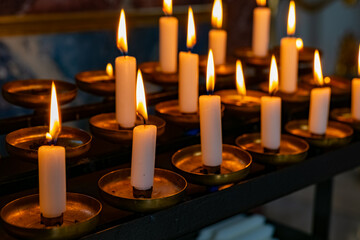 Candles illuminate a serene ambiance in a tranquil religious setting during evening hours
