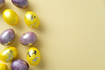 Metallic Easter eggs in yellow and purple hues with speckled patterns, arranged on a pastel yellow background