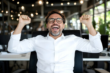 Obraz premium Joyful businessman celebrates success in modern office