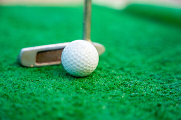 Mini-golf clubs and balls on artificial grass. Family vacations or resort. 