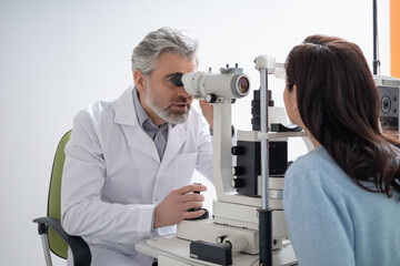 Male optician testing woman sight and providing eye consultation