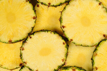 Pineapple juicy yellow slices background. Top view.