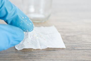 small particles of microplastics collected in water in a filter by researcher, contamination of the environment and aquatic environment.