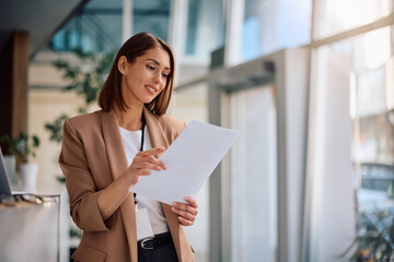 Female manager going through business reports while working at corporate office.