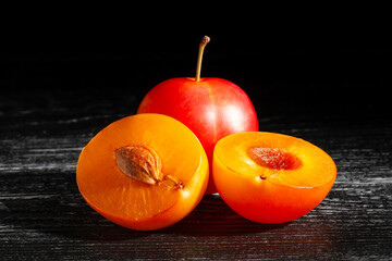 sliced plum on black wood background