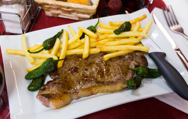 Juicy beef steak with vegetable garnish of fried potatoes and baked jalapenos