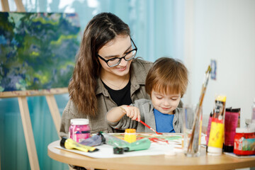 Fototapeta premium Mother and son painting together in their room