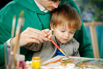 Father and son spend time together painting