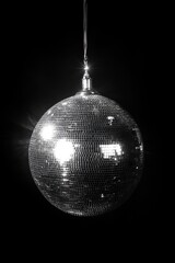 Silver disco ball hanging on black background