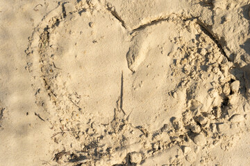 finger painted valentine heart on sandy beach and bright sunshine