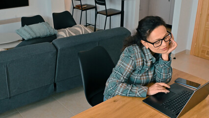 Woman Working at Home on Laptop in Cozy Living Space