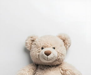 Obraz premium Soft toy bear lies on a white background. Top view, flat lay