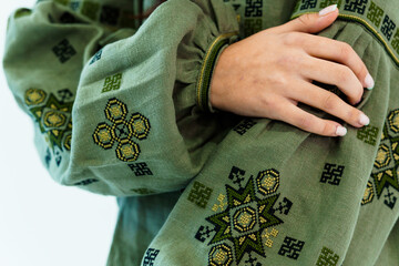 Close-Up of Hand Embroidered Green Fabric Featuring Traditional Geometric Patterns and Decorative...