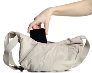 Hand puts phone in beige bag on white background isolated