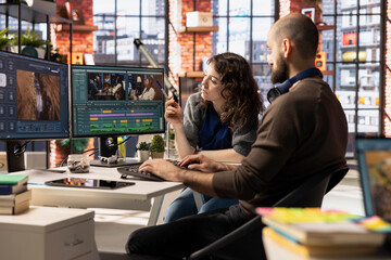 Creative team of editors collaborating on a movie montage project, using AI chatbot and post...