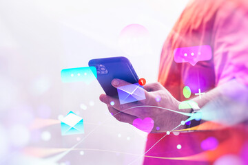 A man wearing a orange vest holds a smartphone displaying chat and email notifications, surrounded by vibrant digital icons.