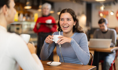 Two women talking over cup of coffee in a cafe
